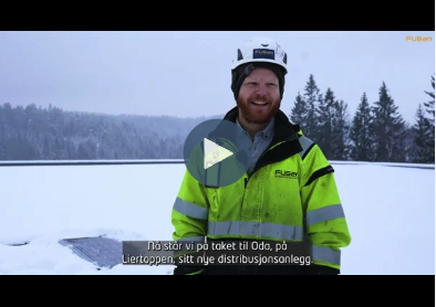 Skjermbilde av videoen solceller fra A-Å. mann i gul jakke med smil om munnen i et vinterlandskap.